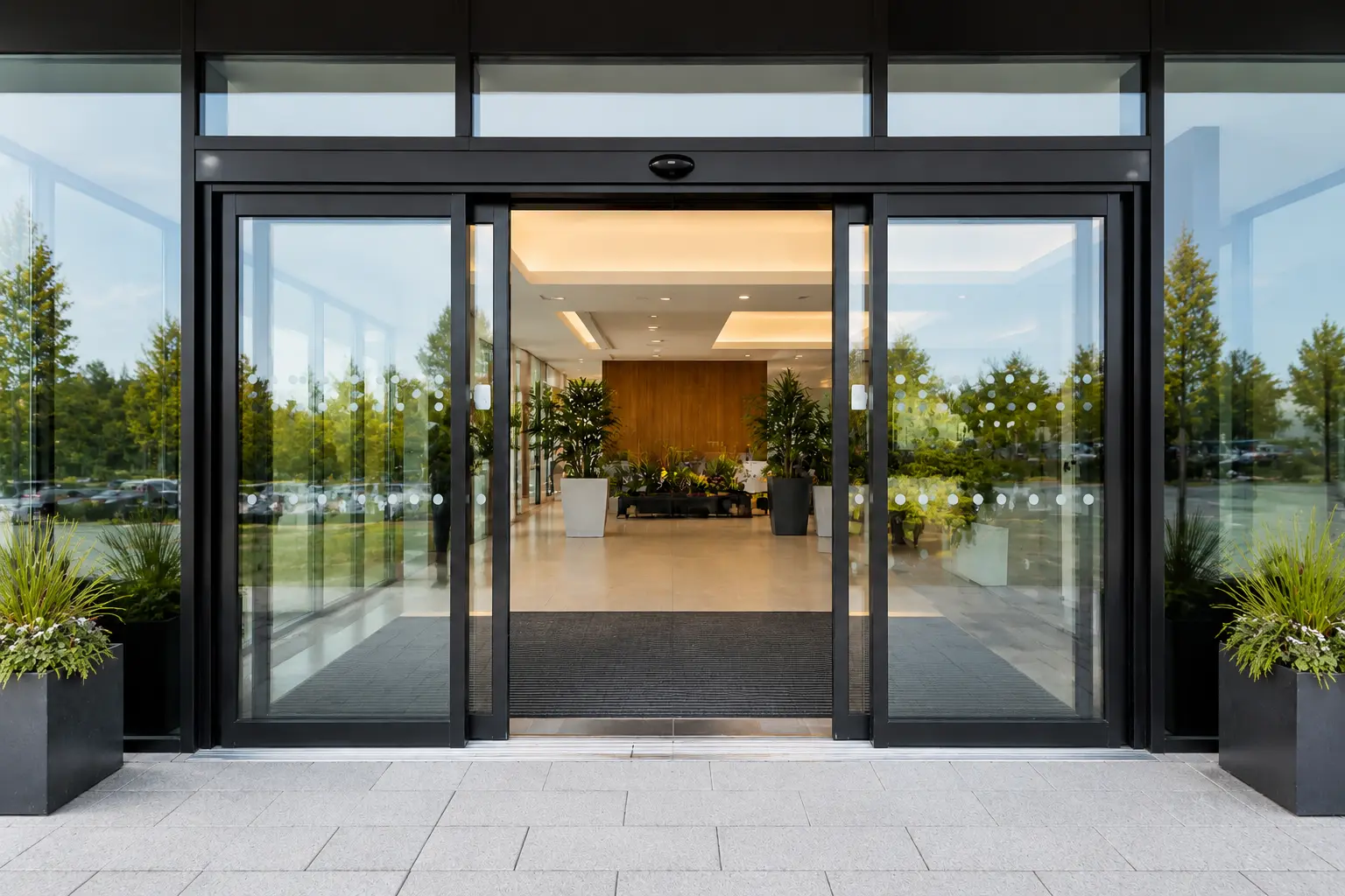 Automatic doors – modern commercial entrance with greenery and DDA compliant hands-free entry