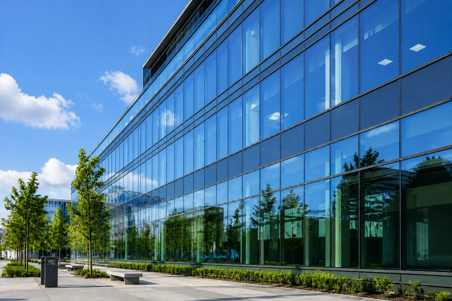 Curtain walling glass facade – modern office building on a sunny day showing full glass exterior